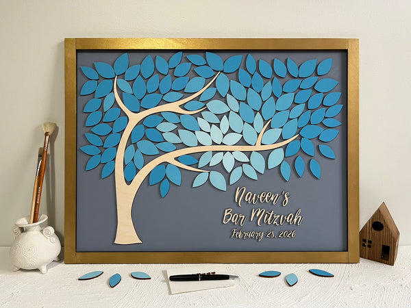 Decorative tree on a board with blue leaves on a grey background, featuring personalized text with a gold frame made for a Bar Mitzvah celebration