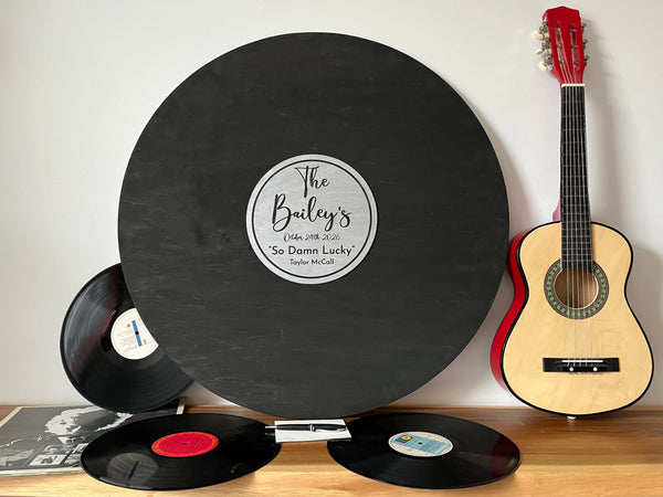 Vinyl records and a guitar on a wooden surface with a white background