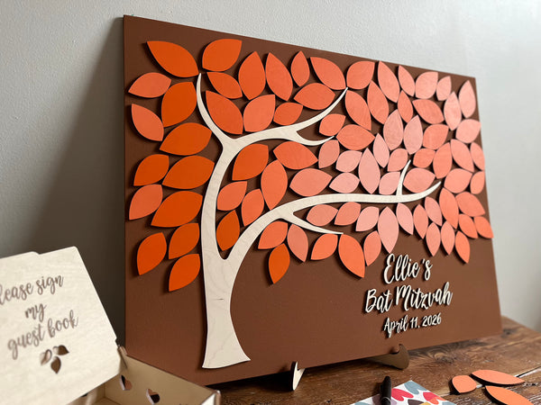Decorative guest book with a tree design made for a  Bat Mitzvah, on a brown background with orange leaves