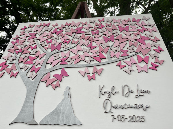 Decorative wall art with pink butterfly design and silhouette of a girl personalized with names and date made to be used as a guest book at a Quince celebration