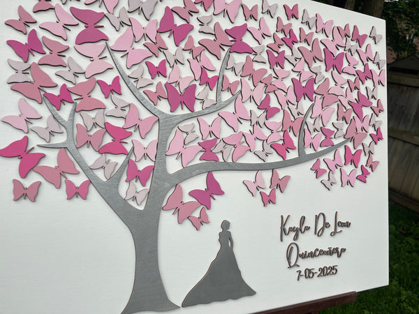 Decorative wall art with pink butterfly design and silhouette of a girl personalized with names and date made to be used as a guest book at a Quince celebration