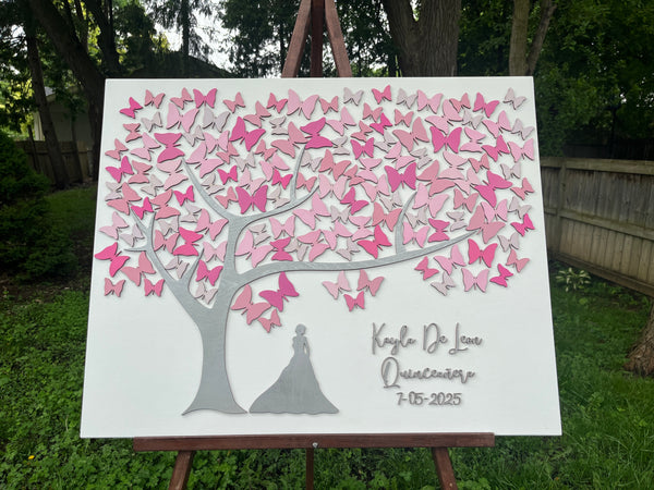 Decorative wall art with pink butterfly design and silhouette of a girl personalized with names and date made to be used as a guest book at a Quince celebration