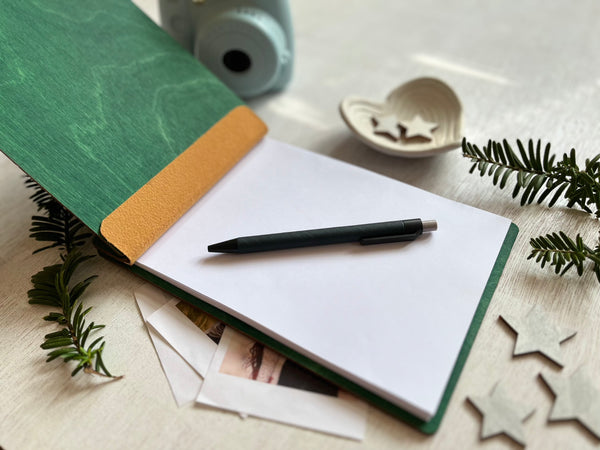 Notebook with a pen on a table with decorative items