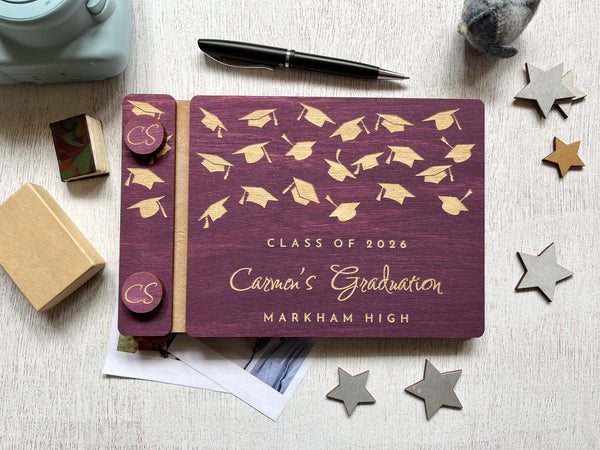 Graduation-themed guest book with caps design on a purple background, personalized with a name, school and Class of 2026
