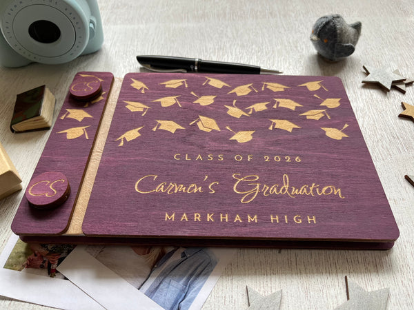 Graduation-themed guest book with caps design on a purple background, personalized with a name, school and Class of 2026