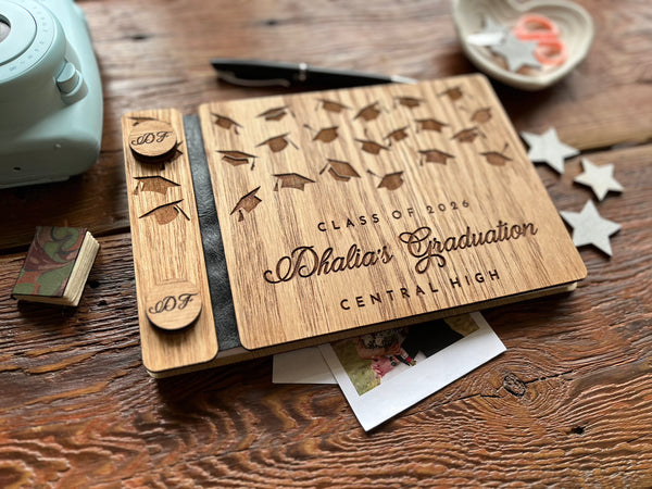 Wooden graduation album with decorative elements on a wooden surface