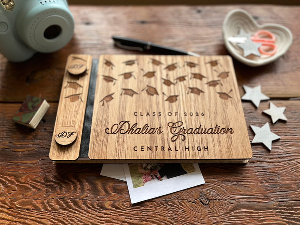Wooden graduation album with 'Class of 2026' design on a wooden surface.