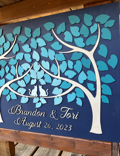detail of the teal cats guest book with two trees coming as one