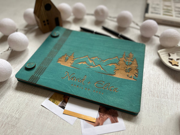 personalized guest book with engraved wood covers and teal stain with mountains and trees