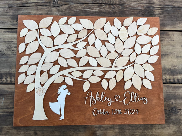 a rustic guest book alternative with tree and leaves to sign personalized with the names of the bride and groom