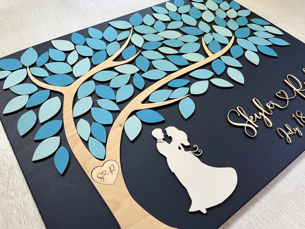 the guest book is personalized with the names of the newlyweds and their initials in a heart in the tree