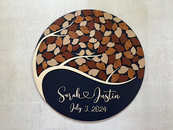 detail of fall round guest book with personalized names, tree of life, leaves to sign and personalized names with a heart in between names