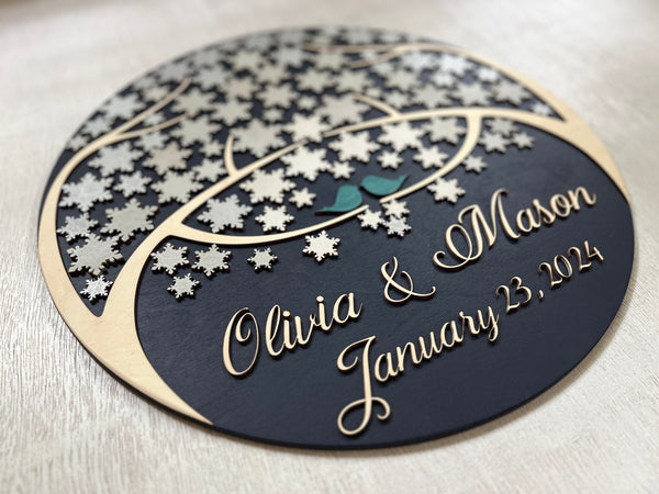 side detail of round guest book alternative with personalized names and date for wedding and snowflakes to sign