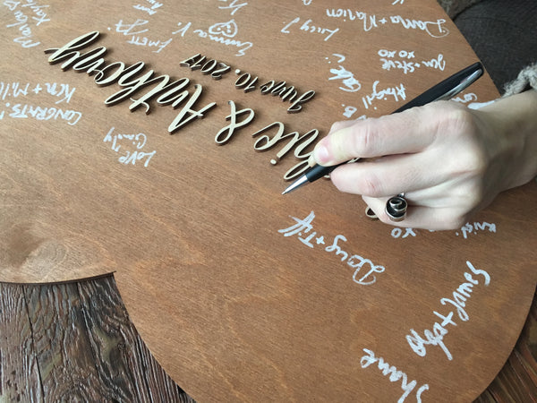 hand signing a brown stain guest book