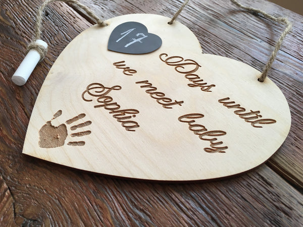 The text is engraved and customized with the baby name and a little handprint