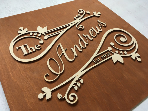 This square last name sign is made on brown wood stain base and natural wood lettering.
