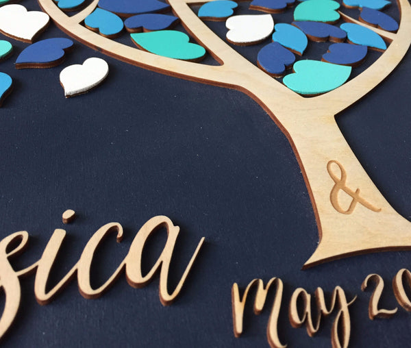 detail of wedding guest book with & sign engraved in the tree