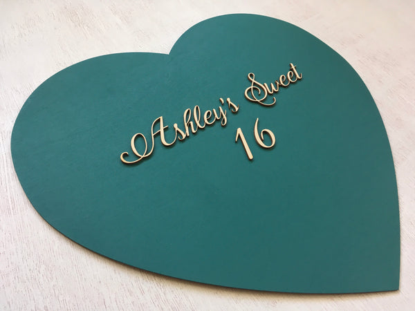 detail of sweet sixteen heart shaped sign on teal with wood 3D lettering
