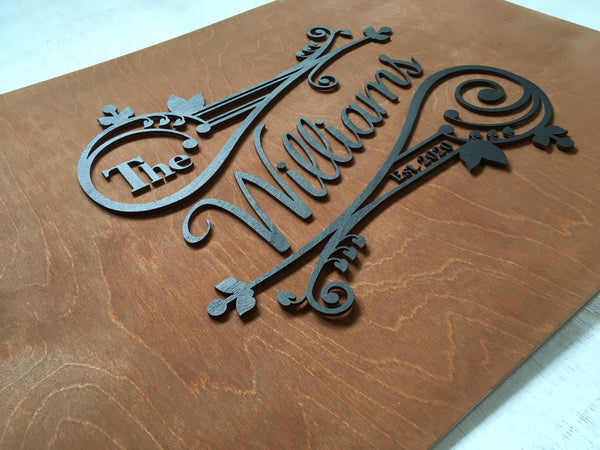 Detail of the personalized last name sign that comes with a whimsical design with leaves and swirls