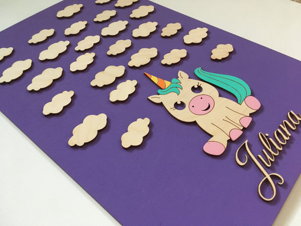 detail of unicorn and clouds kids room sign made of wood and custommized with colors and name