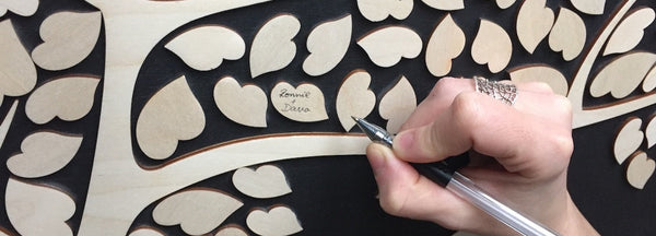 hand signing a SignYouStyle guestbook to show real size of hearts