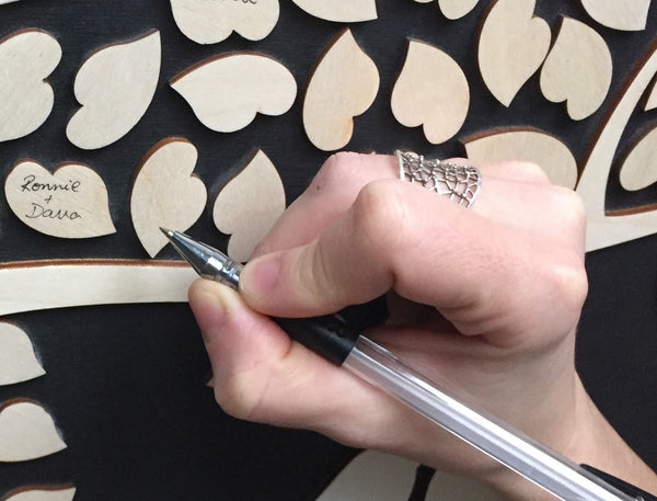 a hand signing an alternative guest book made by SignYouStyle