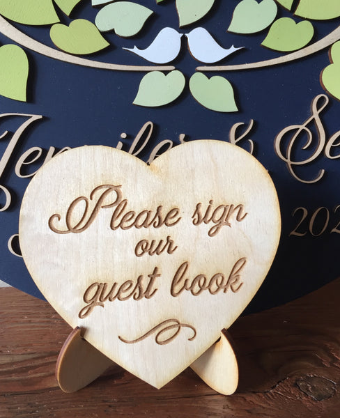 a little heart sign with stand that is engraved with the text please sign our guest book