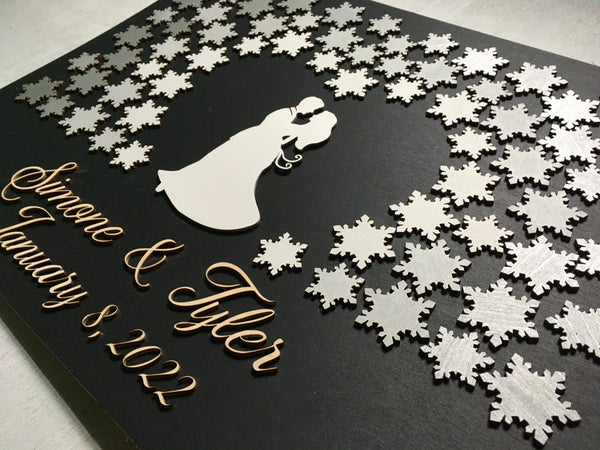 side view of the winter guest book showing the embracing couple that is surrounded by the silver- grey snowflakes in a subtle ombre effect