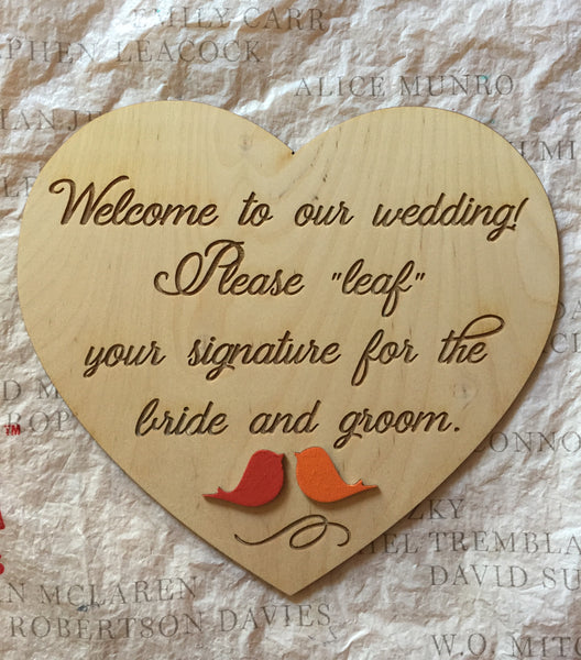 Pair the guest book with this heart sign that welcomes everybody and asks your wedding guests to "leaf" their signature on the guestbook. The sign comes with a holder and the text can be customized. There is also a pair of love birds on the bottom of the sign, painted in red and orange to match the guest book, you can request to customize the colors. 