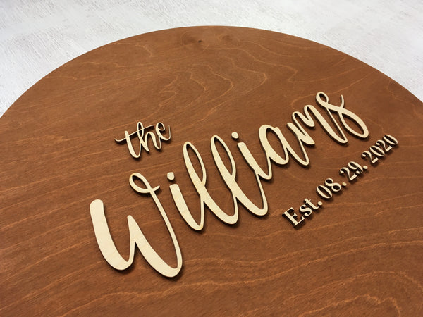the family name is added on top of the round surface that is stained with brown stain