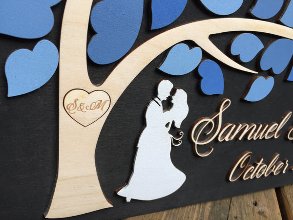 the guest book alternative features a couple and a heart engraved with initials in the tree trunk