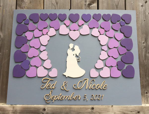 the guest book alternative is made with a couple dancing in the middle of purple shades of hearts that form a heart to surround the couple