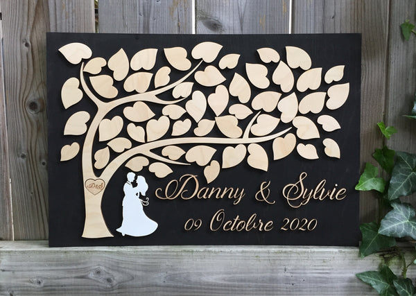 the guest book is made in 3D with a tree of life, leaves to sign, a couple under the tree and the names and date of the couple signyoustyle.com.