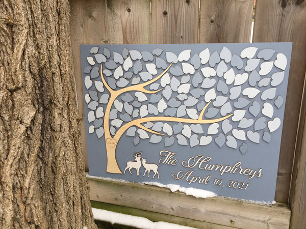 the guest book is made with deer and a tree with leaves for wedding guests to sign