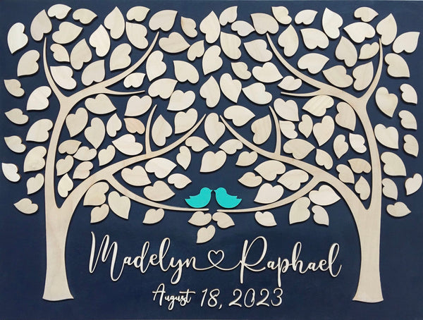the guest book is made with leaves that will be signed by each guest and the names of the newlyweds is written in wooden lettering under the trees