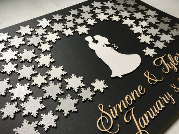 the snowflakes form a heart shape around the couple the customized names and date will appear iunder the couple in cut-out lettering in a calligraphic font