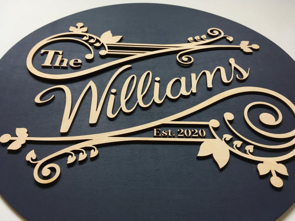 wood family name sign with fancy swirls and vines